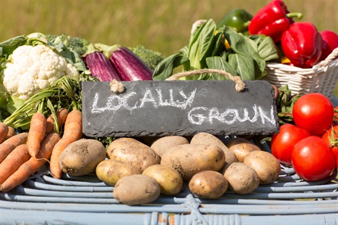 Photo of fresh produce and a sign that says 'locally grown'